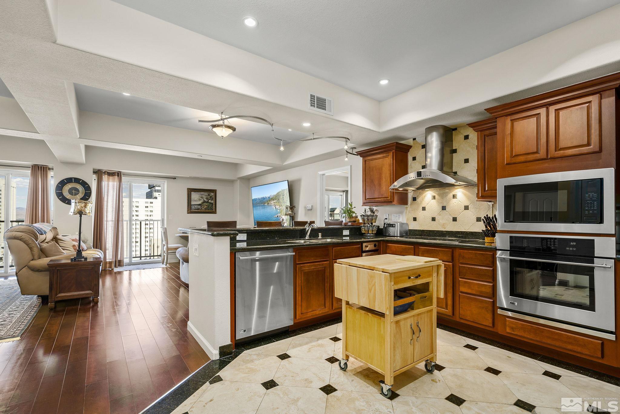 200 West 2nd Street, Unit 1102 Reno, NV 89501 - Photo 3 of 19 a kitchen with stainless steel appliances granite countertop a stove top oven a sink dishwasher and cabinets with wooden floor