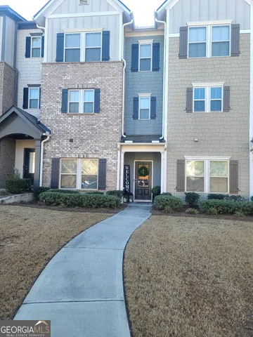 a front view of a brick house with a yard