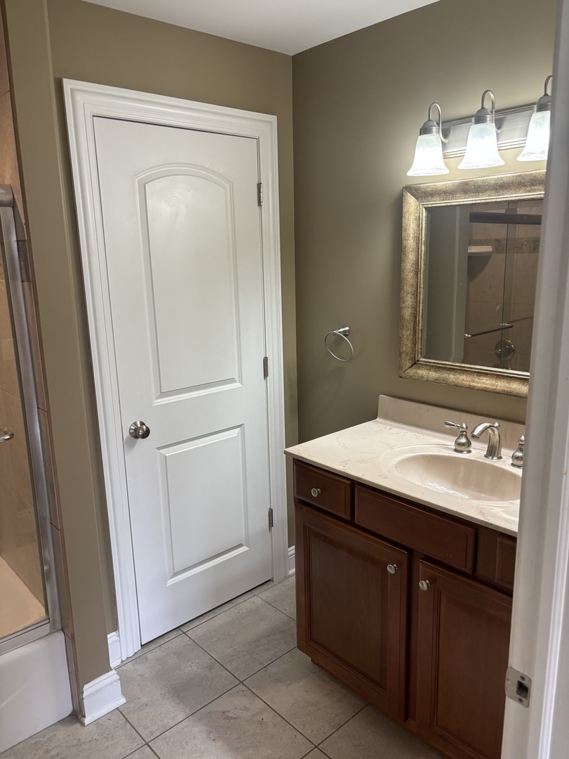 40 Mischa Court, Unit 100 Lake Zurich, IL 60047 - Photo 23 of 36 a bathroom with a granite countertop sink and a mirror