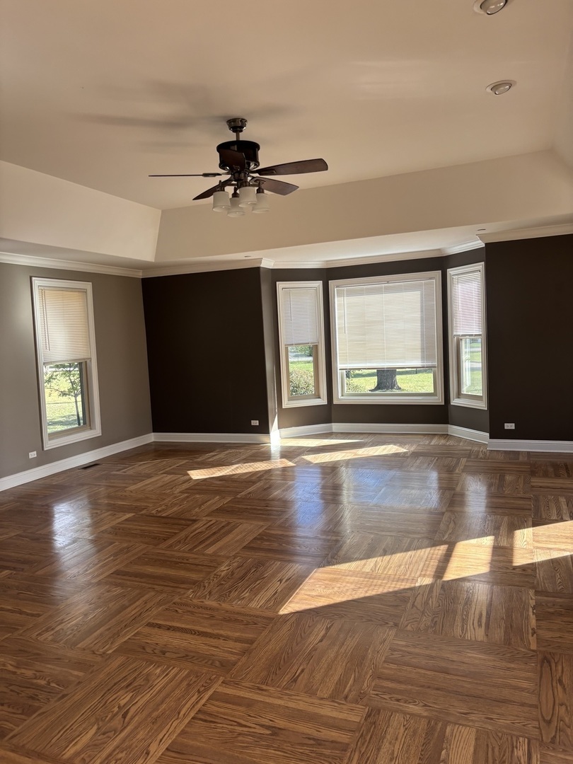 40 Mischa Court, Unit 100 Lake Zurich, IL 60047 - Photo 9 of 36 a view of an empty room with window and wooden floor