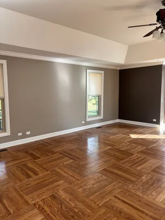 a view of an empty room with window and wooden floor