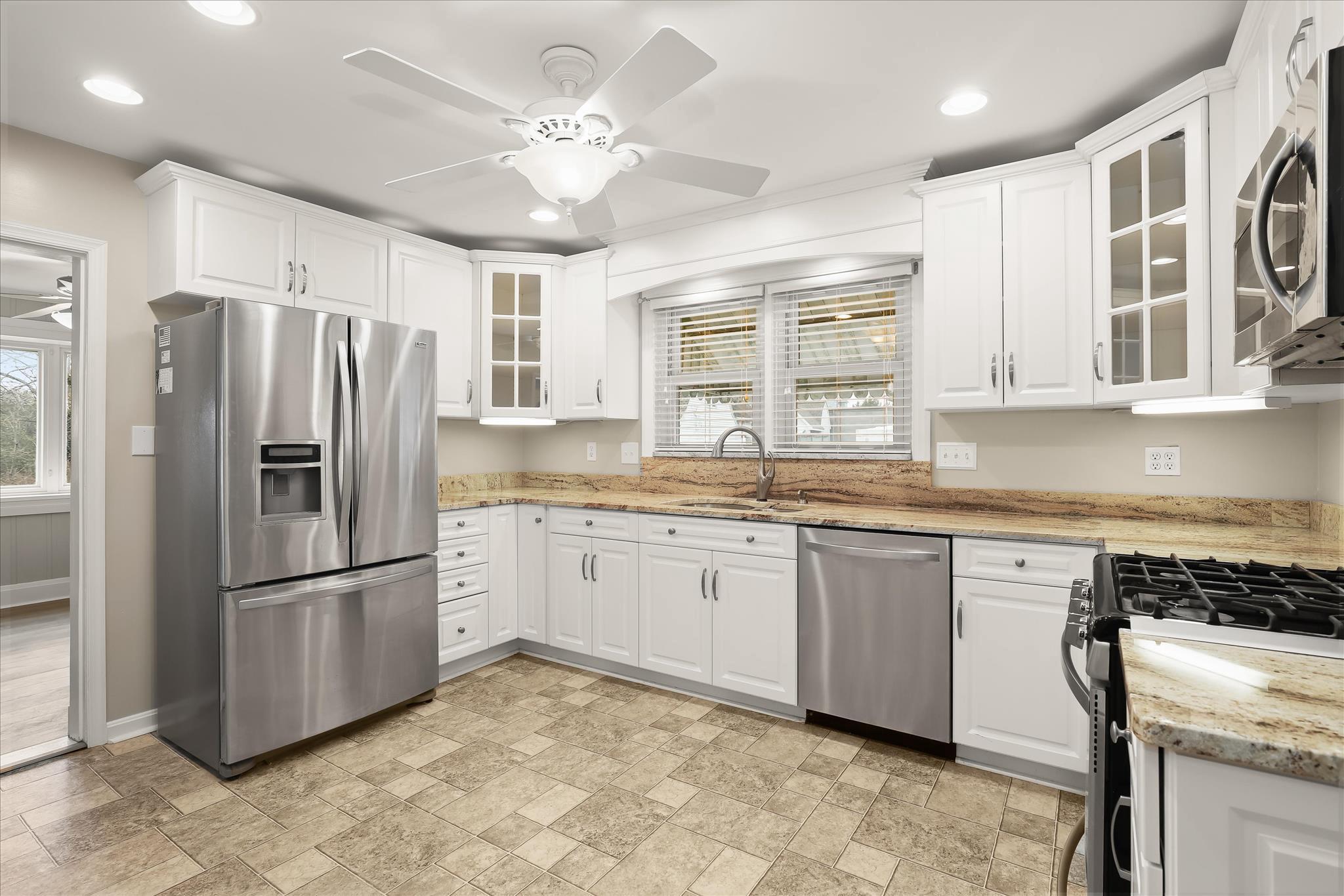 1218 Rustic Avenue Rosedale, MD 21237 - Photo 7 of 34 a kitchen with stainless steel appliances granite countertop a refrigerator a sink a stove a dining table and chairs