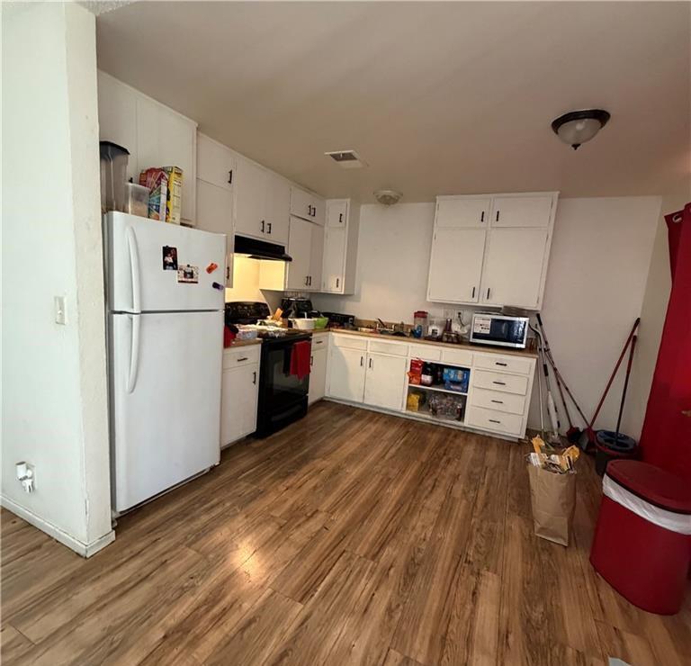 1567 Ellen Court Merced, CA 95341 - Photo 9 of 16 a kitchen with stainless steel appliances a stove top oven a refrigerator a sink and dishwasher with wooden floor