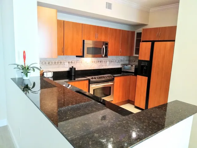 a kitchen with stainless steel appliances granite countertop a sink refrigerator and microwave