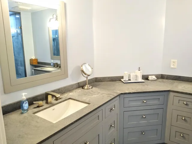 a bathroom with a granite countertop sink and a mirror