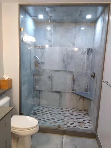 a bathroom with a sink a toilet and shower