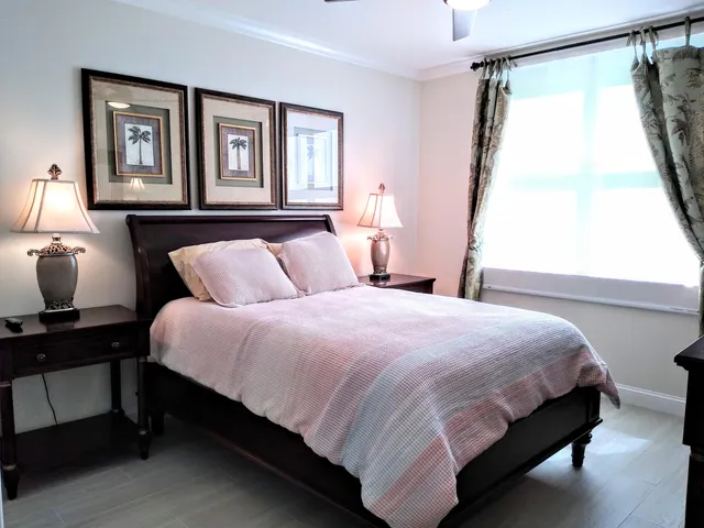 a bedroom with a bed lamp and a window