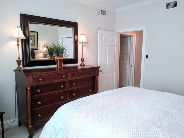 a bedroom with a bed and a mirror on dresser