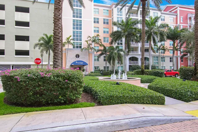 a front view of multi story residential apartment building with yard and green space