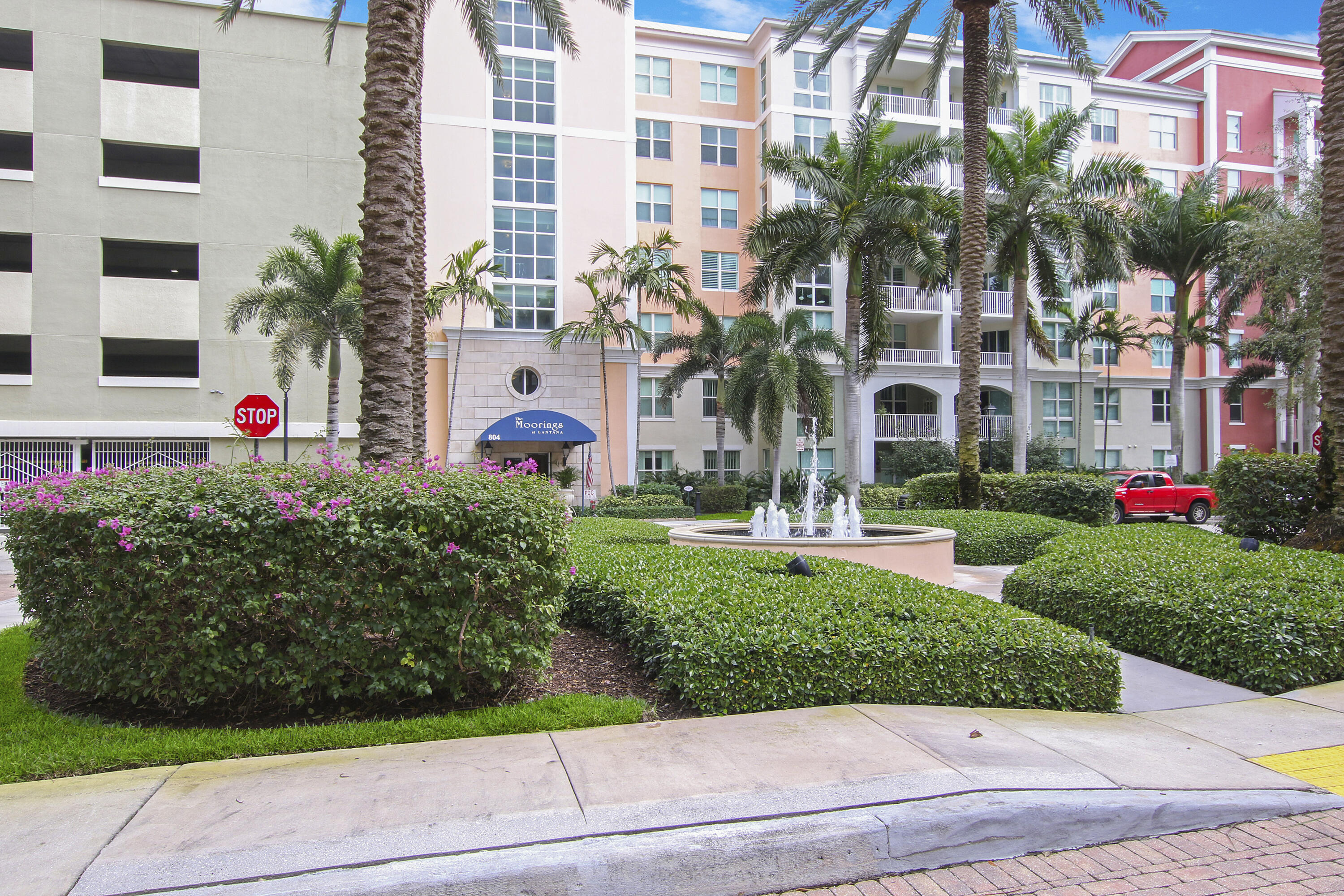 806 East Windward Way, Unit 410 Lantana, FL 33462 - Photo 23 of 33 a front view of multi story residential apartment building with yard and green space