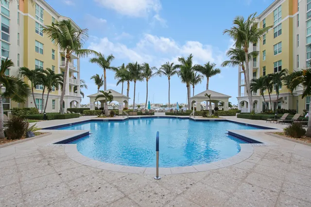 a view of swimming pool with outdoor seating and palm trees
