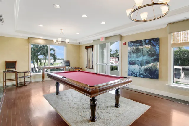 a room with pool table and windows