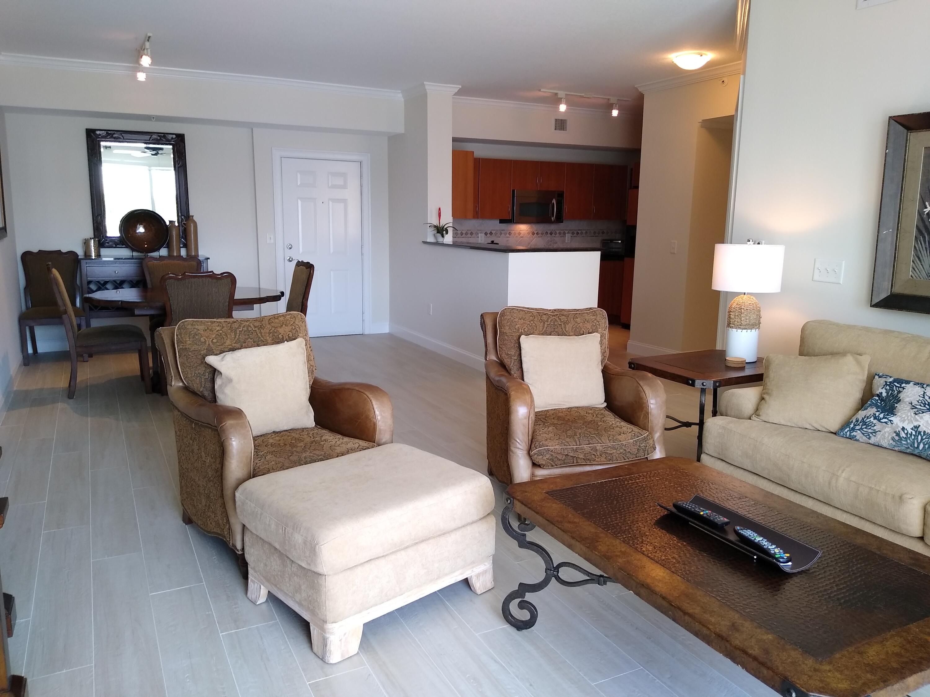 806 East Windward Way, Unit 410 Lantana, FL 33462 - Photo 6 of 33 a living room with furniture a flat screen tv and a window