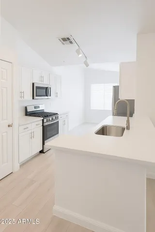 a kitchen with granite countertop a sink a stove and cabinets