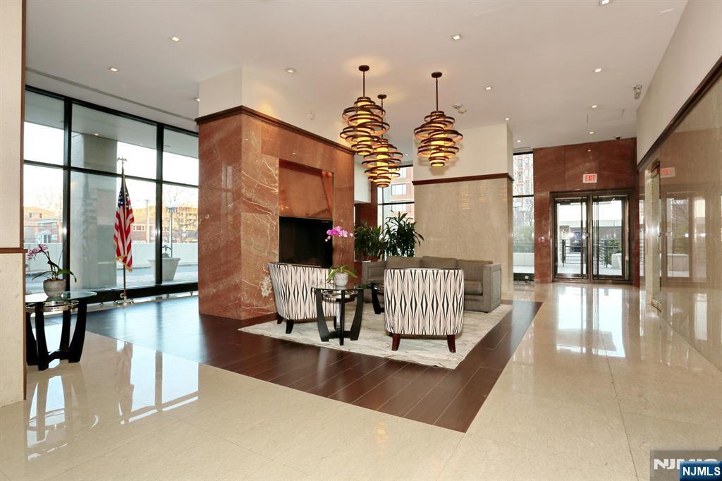 200 Old Palisade Road, Unit 7J Fort Lee, NJ 07024 - Photo 4 of 20 a living room with couches chandelier and a large window