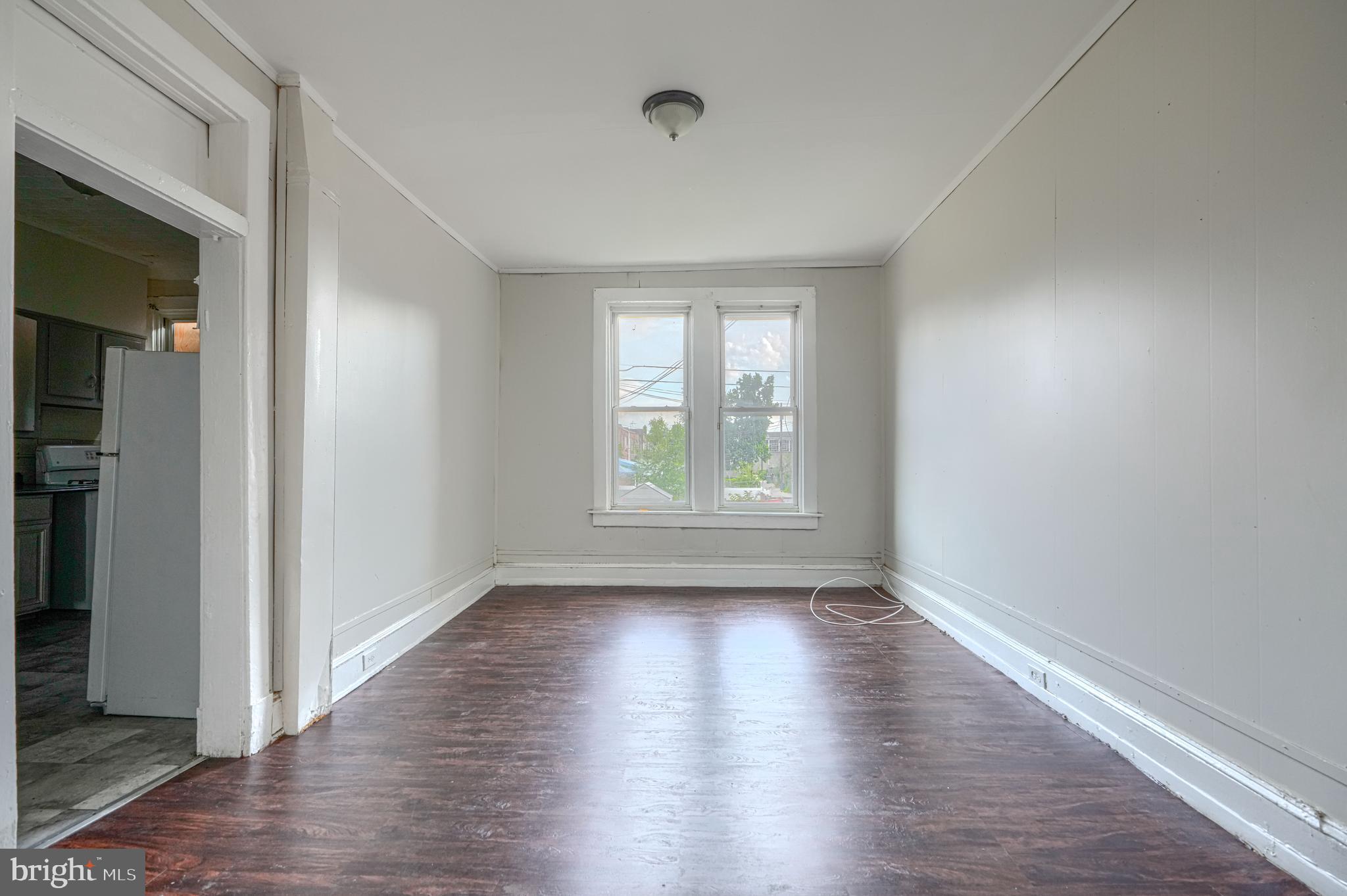 4806 Reisterstown Road Baltimore, MD 21215 - Photo 9 of 34 a view of an empty room with wooden floor and a window