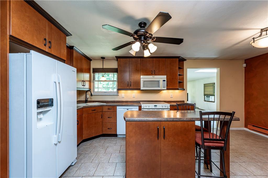 2037 Ridge Road Jeannette, PA 15644 - Photo 8 of 31 a kitchen with stainless steel appliances granite countertop a stove top oven a sink a dining table and chairs