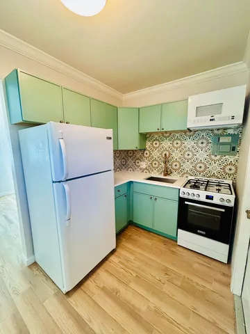 a kitchen with stainless steel appliances granite countertop a refrigerator and a stove