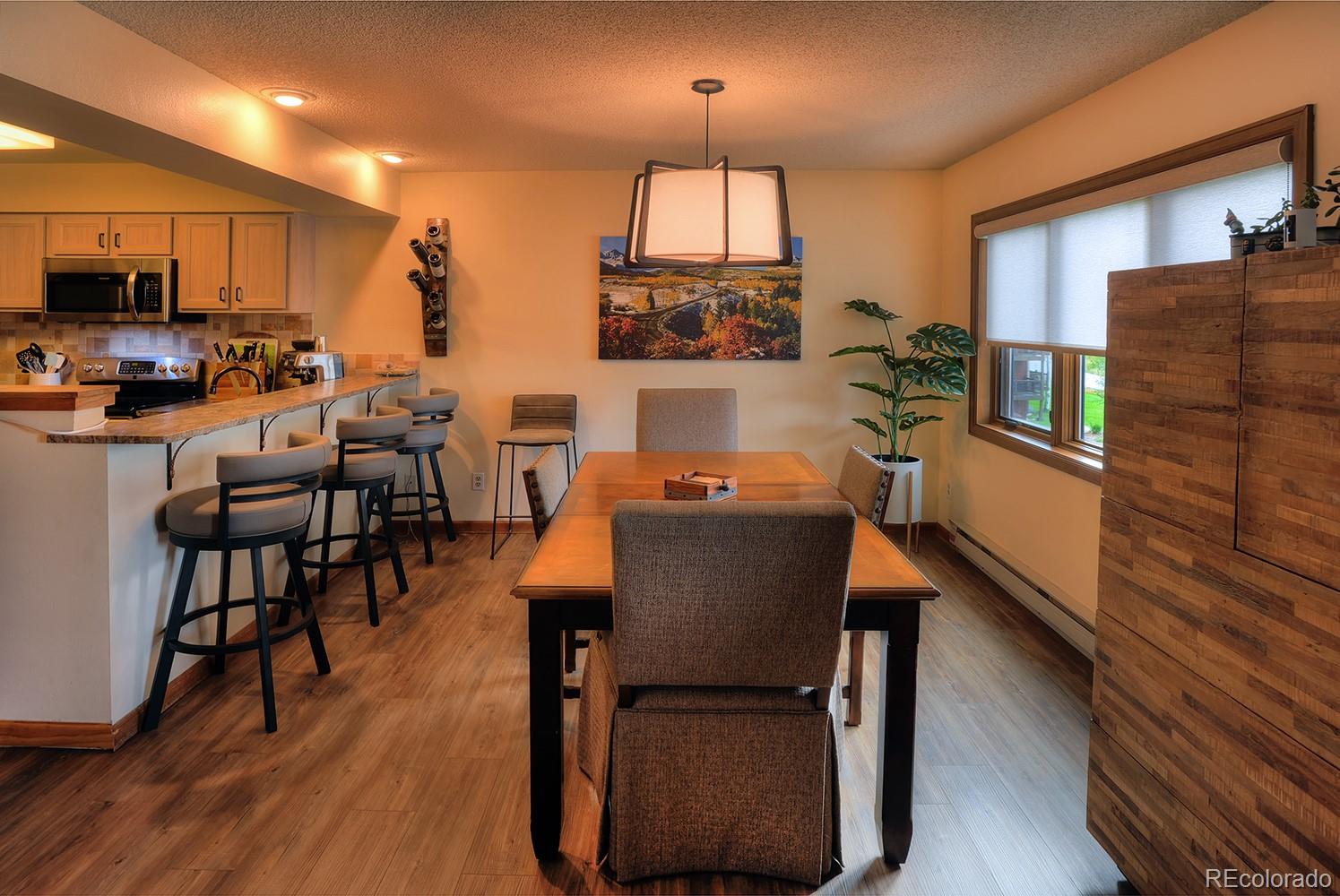 a dining room with furniture a window and wooden floor