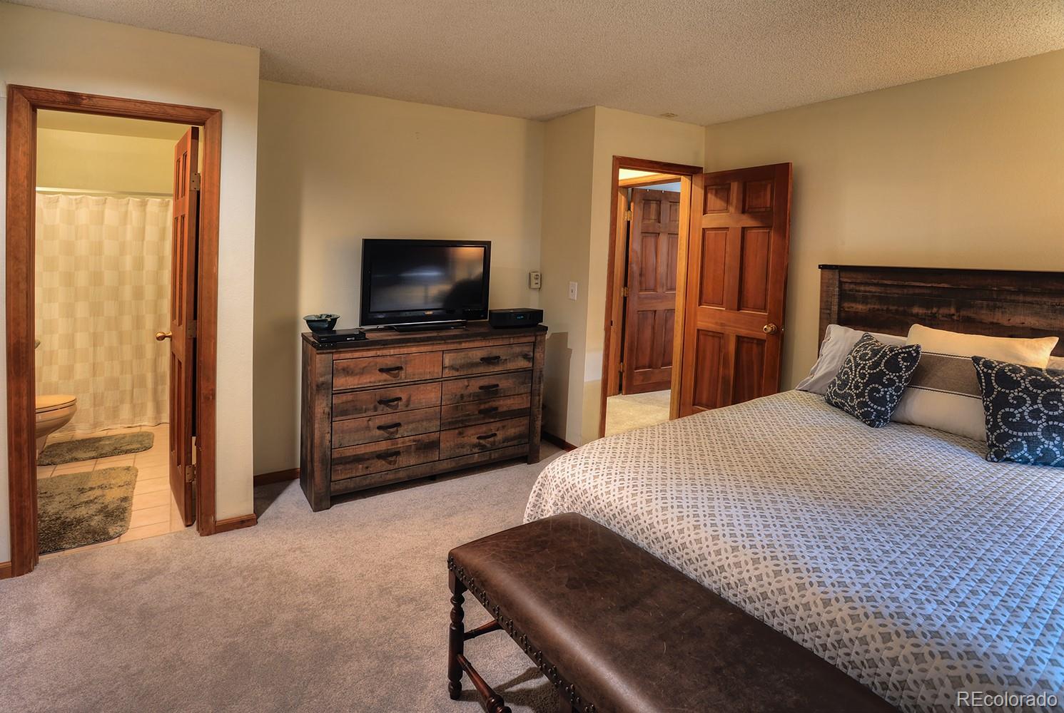 1680 Ranch Road, Unit 203 Steamboat Springs, CO 80487 - Photo 15 of 25 a bedroom with a bed and a flat screen tv