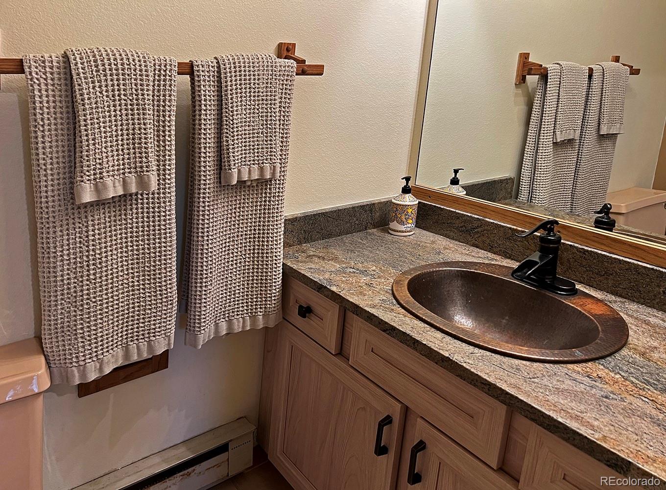 1680 Ranch Road, Unit 203 Steamboat Springs, CO 80487 - Photo 20 of 25 a bathroom with a granite countertop sink and a mirror