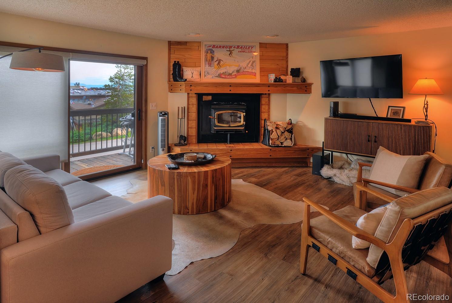 1680 Ranch Road, Unit 203 Steamboat Springs, CO 80487 - Photo 8 of 25 a living room with furniture a fireplace and a flat screen tv