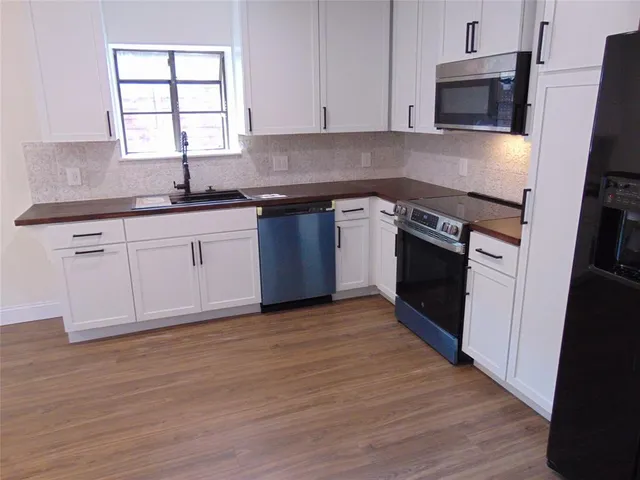 a kitchen with stainless steel appliances granite countertop a stove a sink and a refrigerator