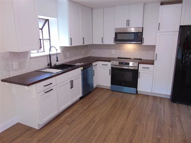 a kitchen with stainless steel appliances a stove a refrigerator and a microwave