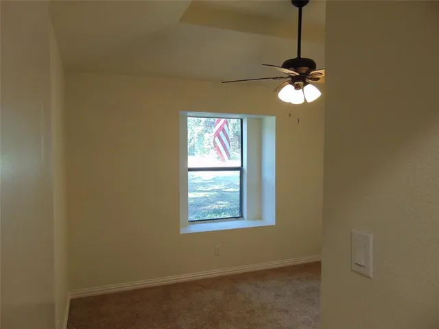 an empty room with a window and a chandelier