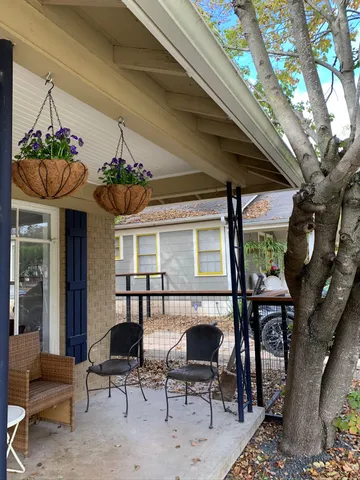 a dining room with wooden floor a chandelier a glass table and chairs