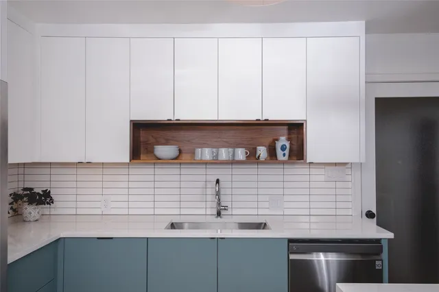 a kitchen with a refrigerator sink and cabinets