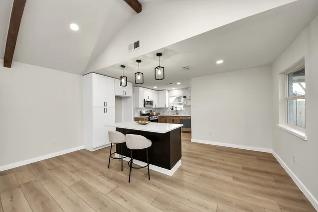 a kitchen with a sink cabinets and wooden floor