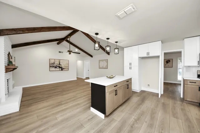 a kitchen with cabinets and wooden floor