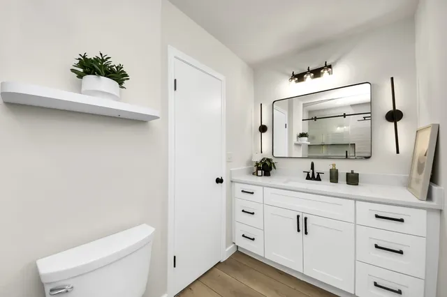 a bathroom with a toilet sink and mirror
