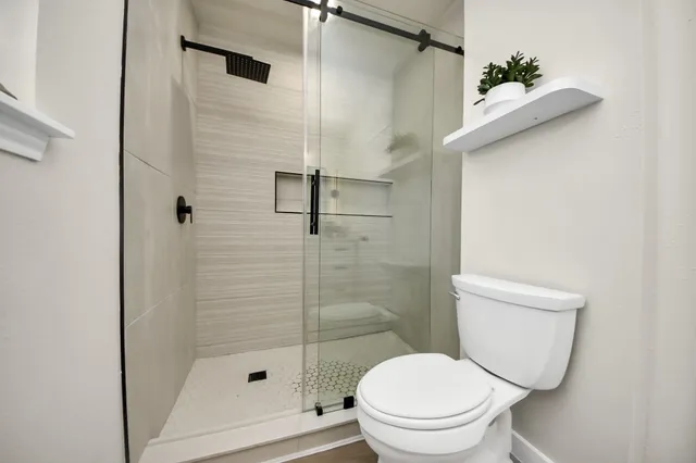 a white toilet sitting next to a bathroom sink