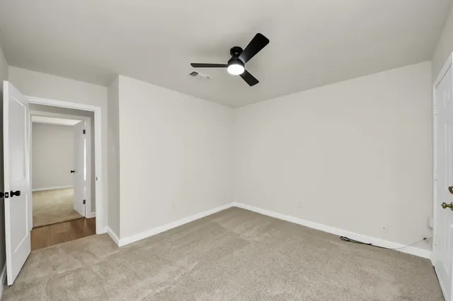 a view of a room with a ceiling fan and hardwood floor