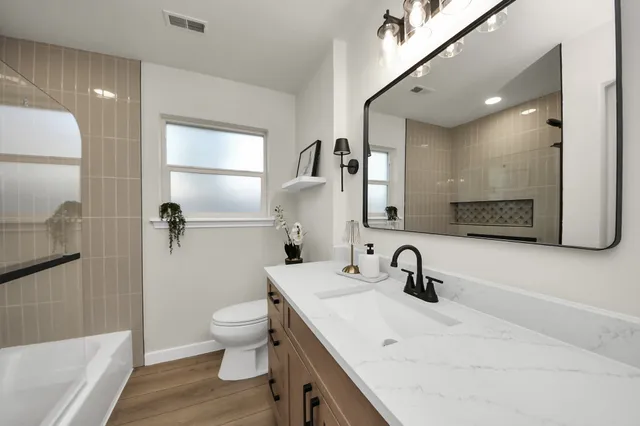 a bathroom with a sink a toilet and shower