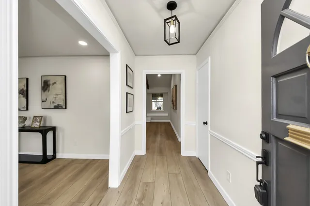 a view of a hallway with wooden floor and furniture