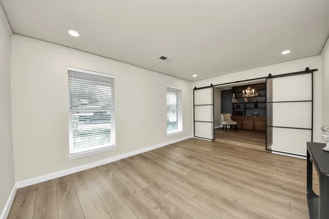 a view of an empty room with a window and a kitchen