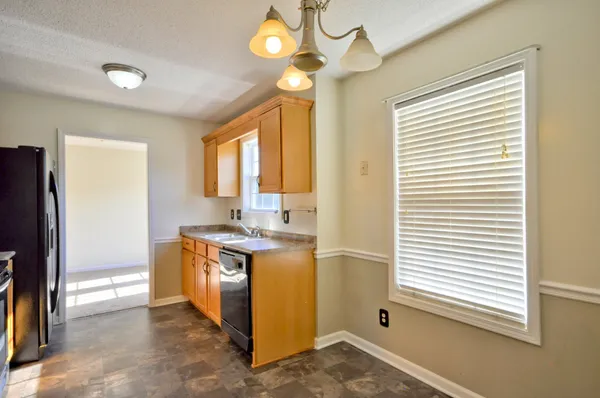a kitchen with a stove a refrigerator and a window