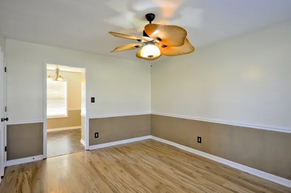 a view of a room with wooden floor and ceiling fan