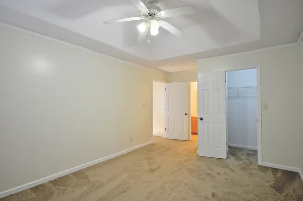 an empty room with closet and a ceiling fan