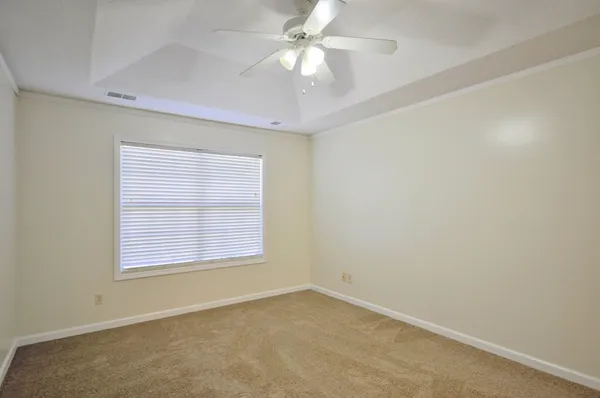 an empty room with a window and a fan