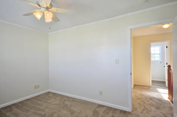 an empty room with closet and a chandelier fan