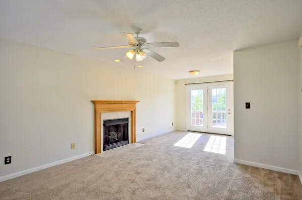 an empty room with windows and fireplace