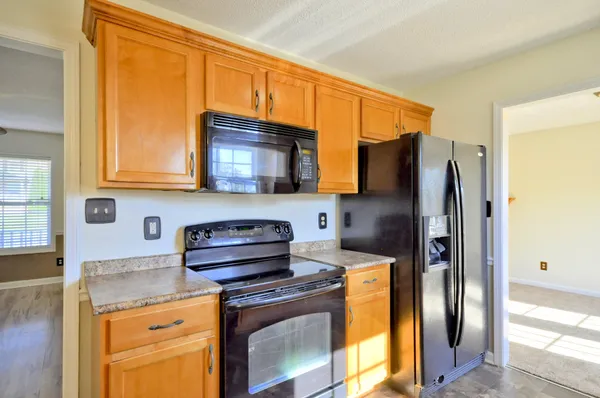 a kitchen with stainless steel appliances granite countertop a refrigerator stove and microwave
