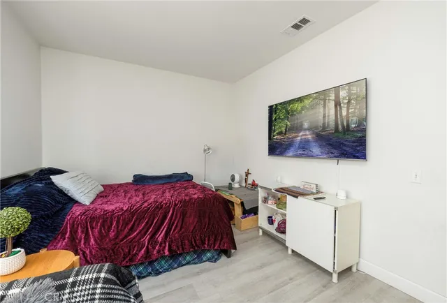 a bedroom with a bed and painting on the wall