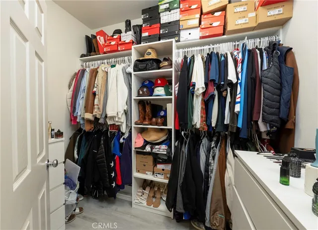 a view of walk in closet with clothes and shoes