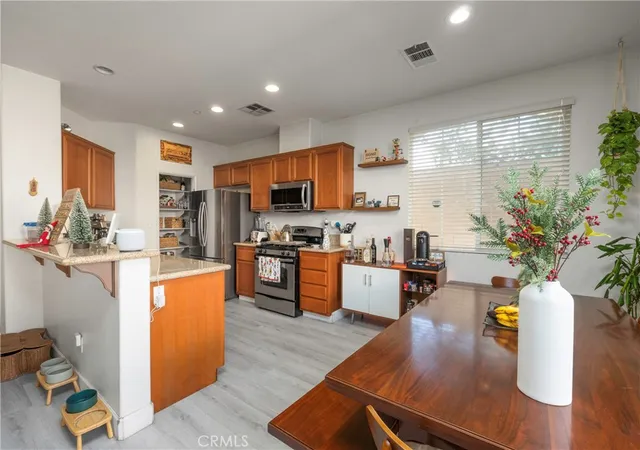 a kitchen with stainless steel appliances granite countertop sink stove refrigerator and cabinets