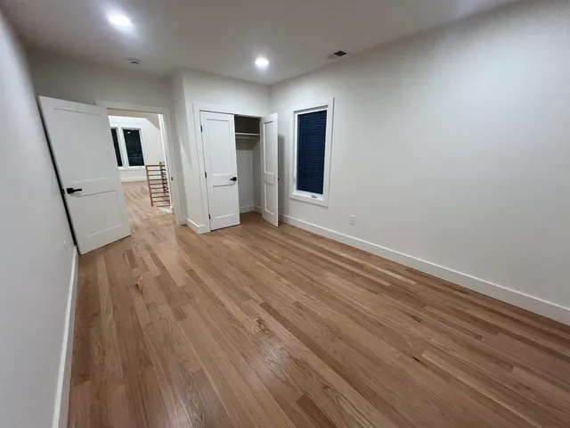 a view of a livingroom with wooden floor and stairs
